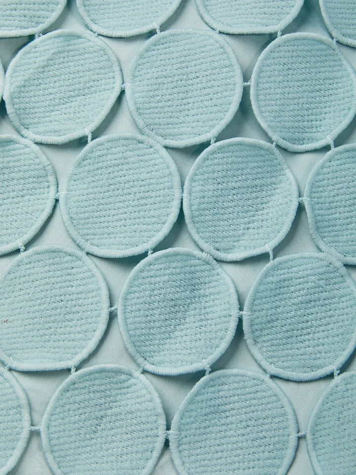 Close up of the stitched round appliqués on the aqua skirt