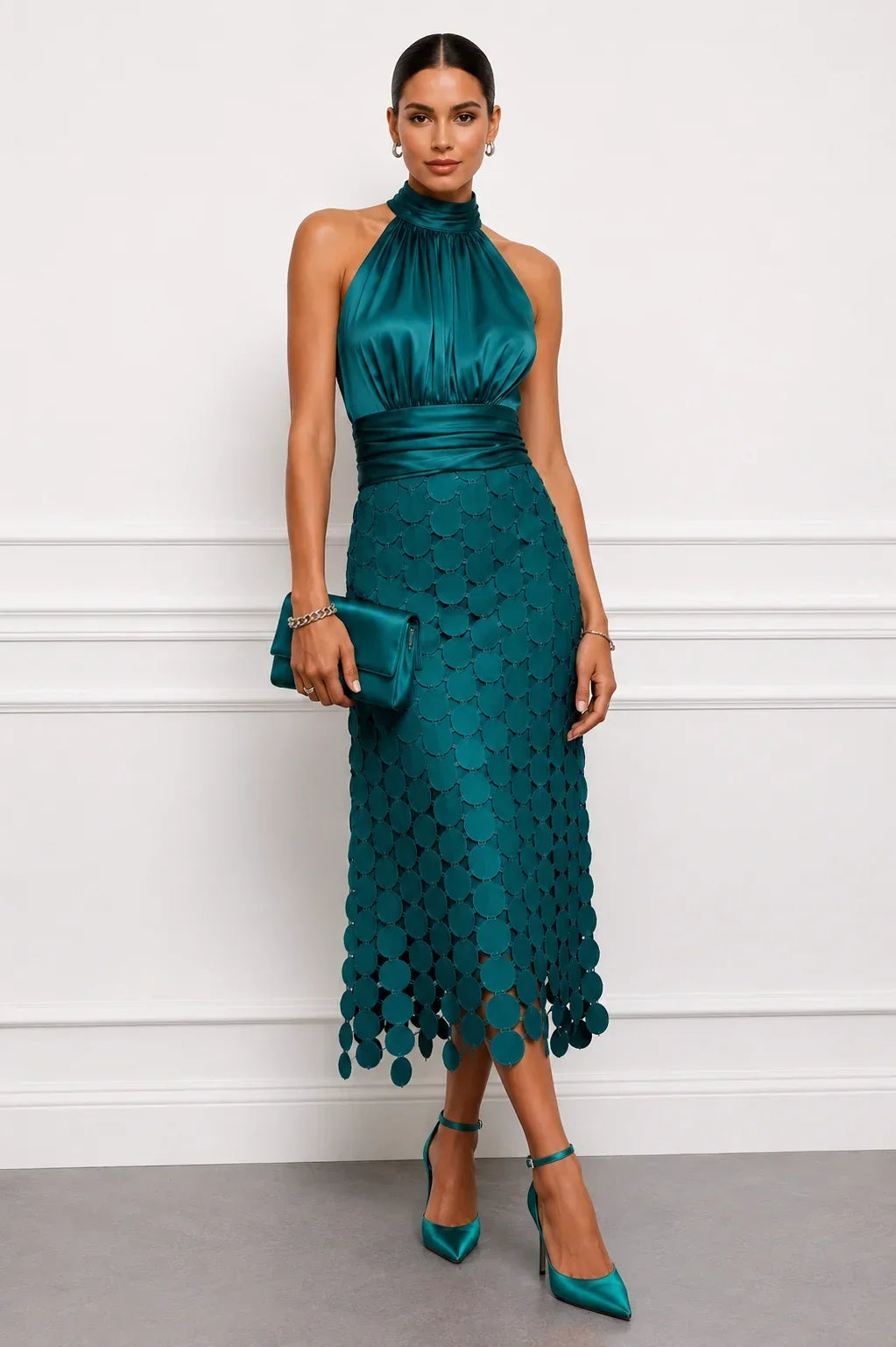 Teal dress with glossy bodice and circle appliqués, styled with a clutch