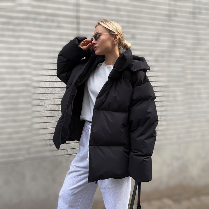 Black oversized puffer jacket worn open with light trousers