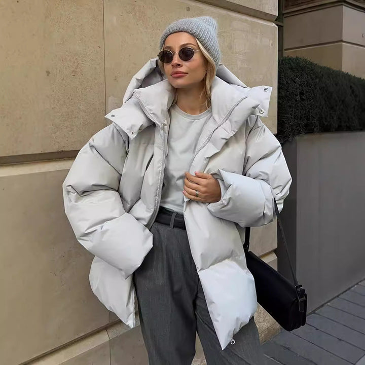 Light grey puffer jacket worn open over a grey top