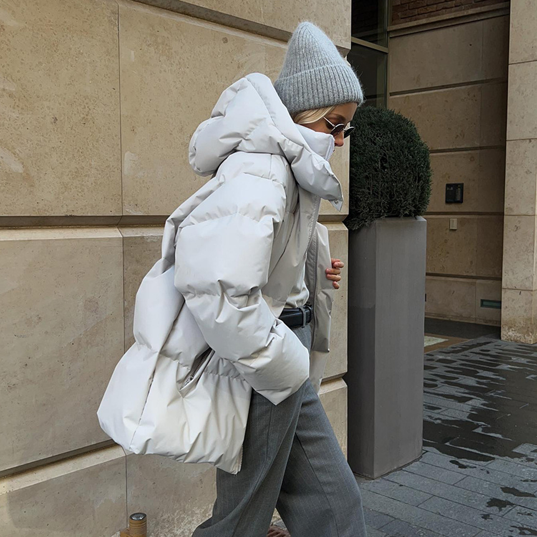 Side view of the light grey puffer jacket with the hood up