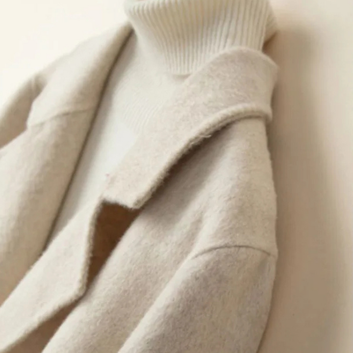 Detail of the cream notch lapel worn over a white roll neck