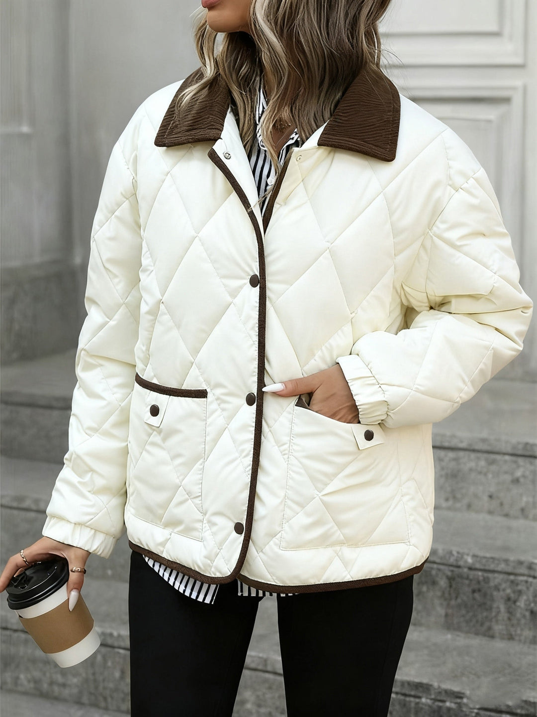 Model in the cream quilted jacket holding a coffee cup