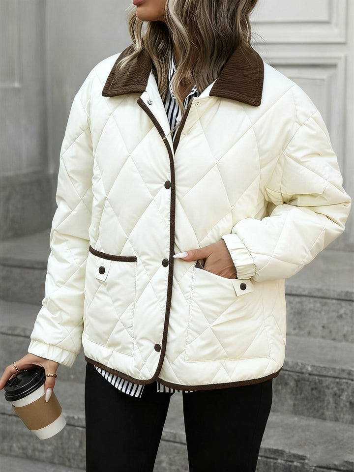 Model in the cream quilted jacket holding a coffee cup