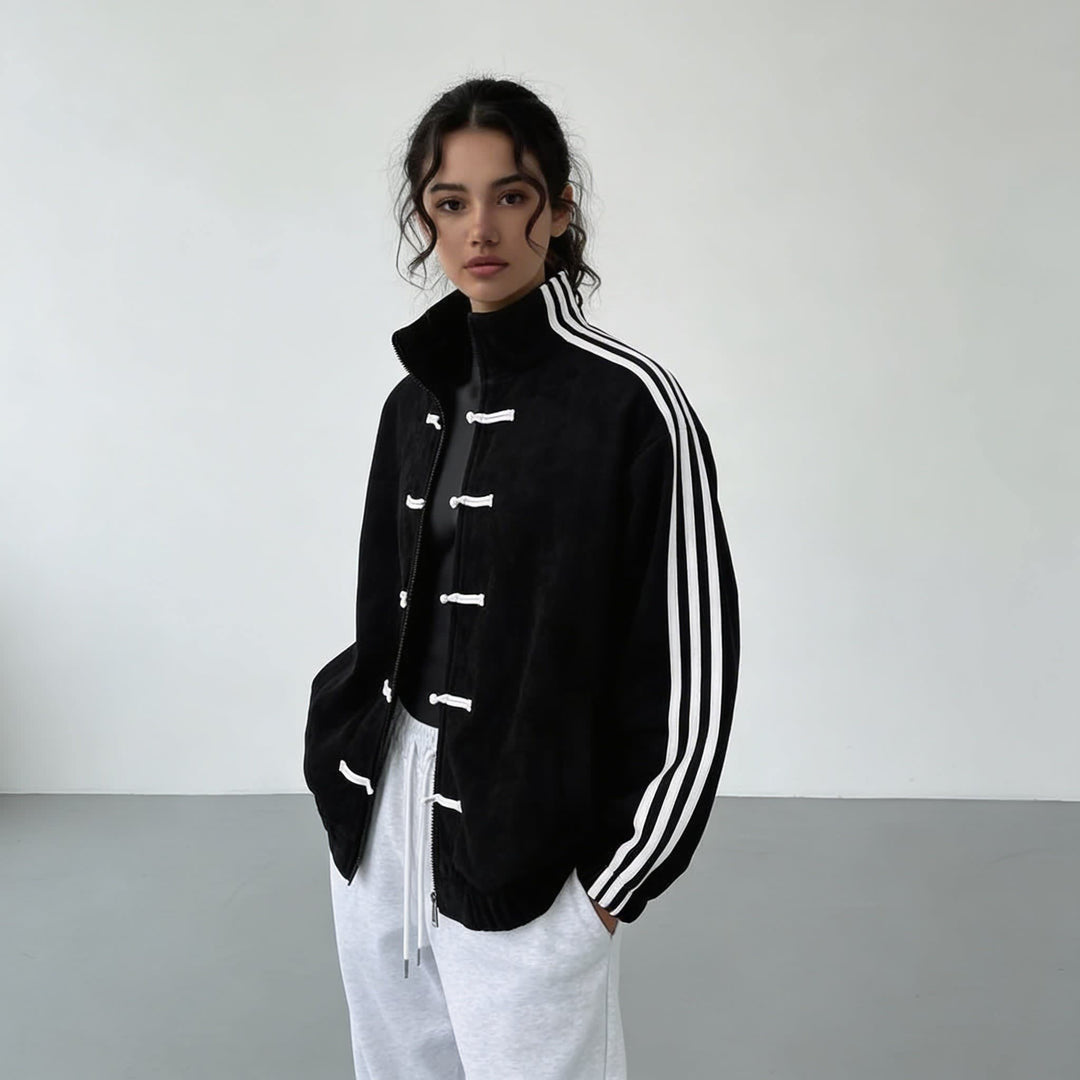 Black track jacket worn open over a white top