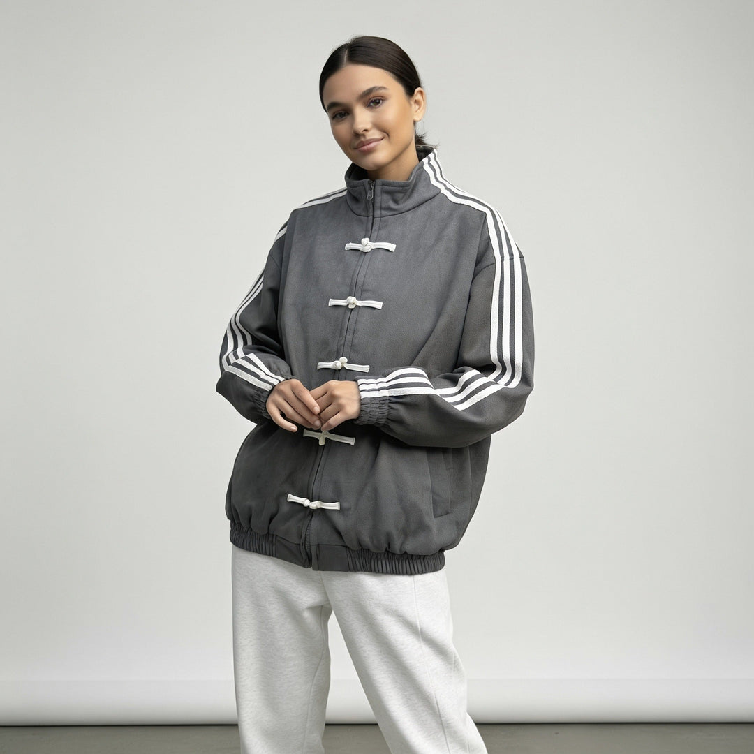Charcoal grey track jacket worn with hands together at the front
