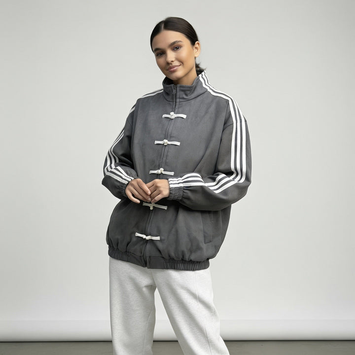 Charcoal grey track jacket worn with hands together at the front