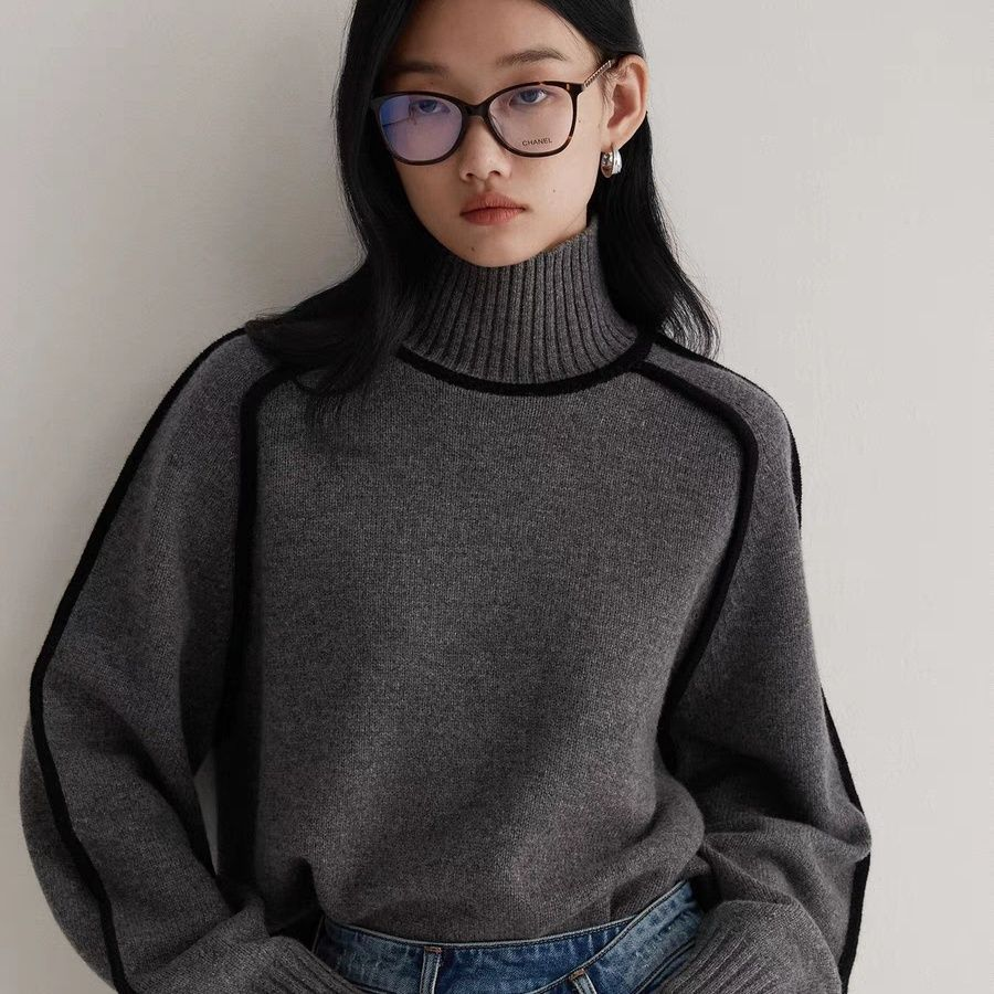 Close view of the charcoal grey ribbed roll neck and piped seams