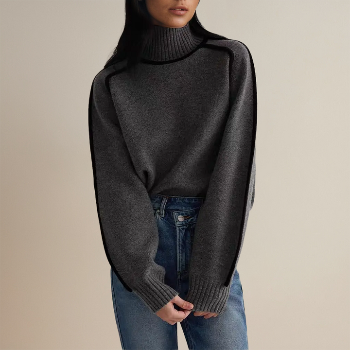 Model in the charcoal grey turtleneck, hands resting in front
