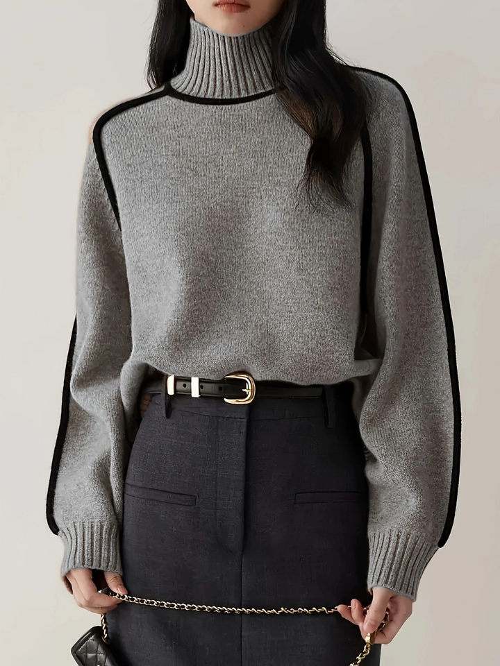 Light grey roll neck jumper tucked into a dark skirt with a belt