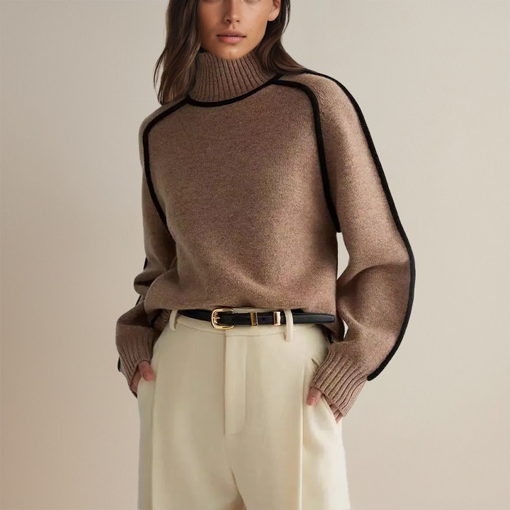 Taupe jumper tucked into cream trousers with a black belt