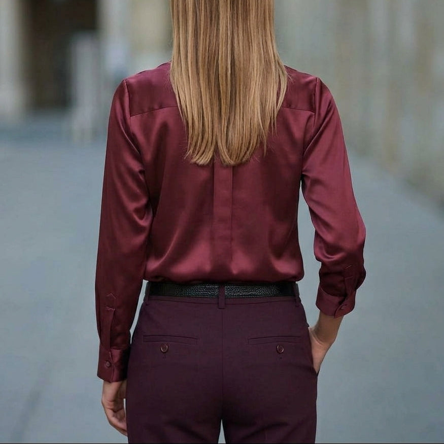 Back view of the burgundy blouse with a yoke seam and buttoned cuffs
