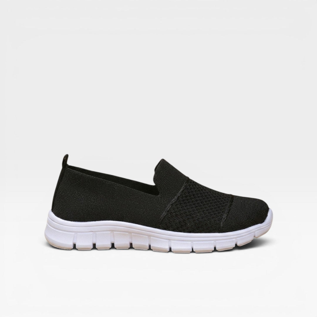 Black slip on trainers with a white cushioned sole