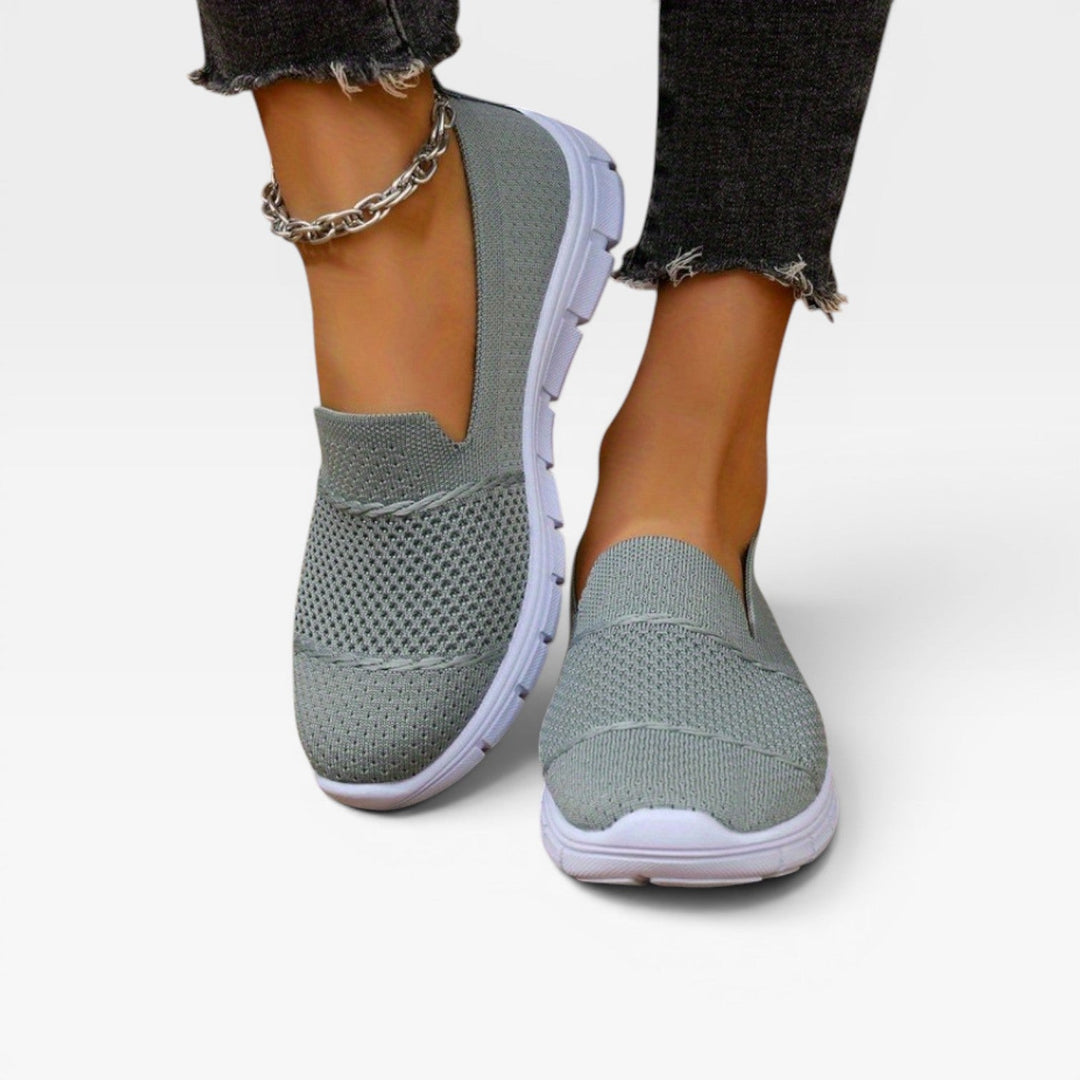 Model standing in grey knit slip on trainers
