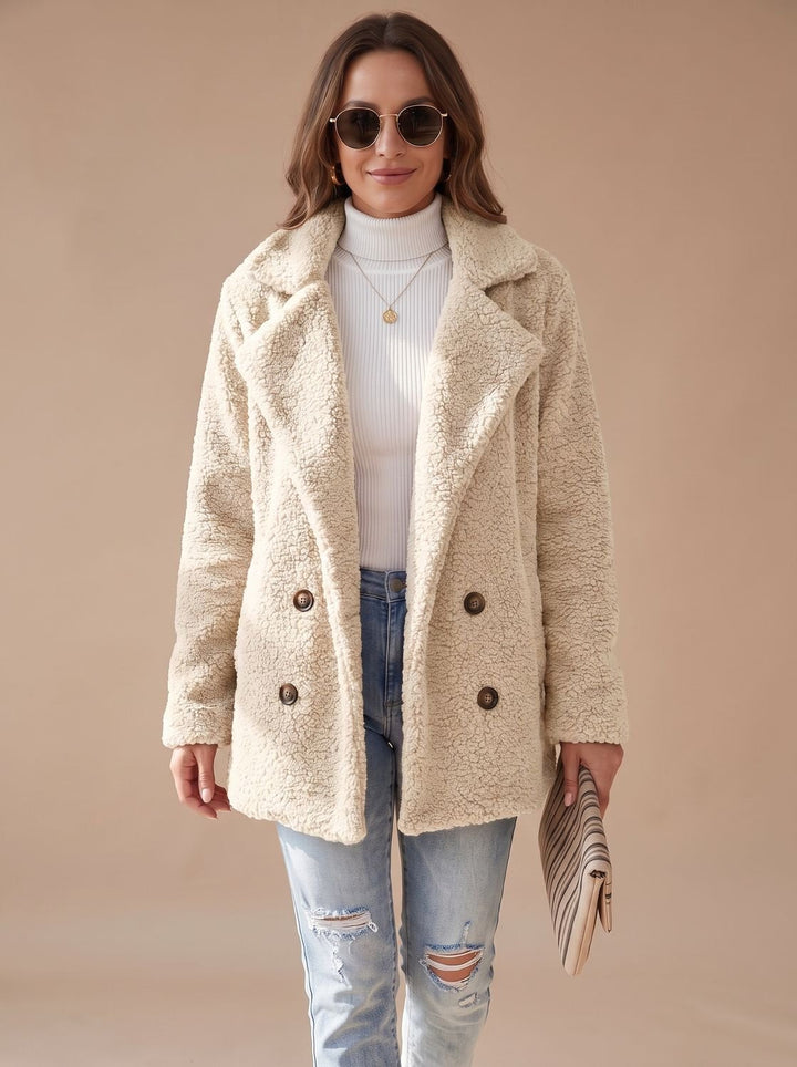 Cream teddy coat worn open with light denim and a clutch