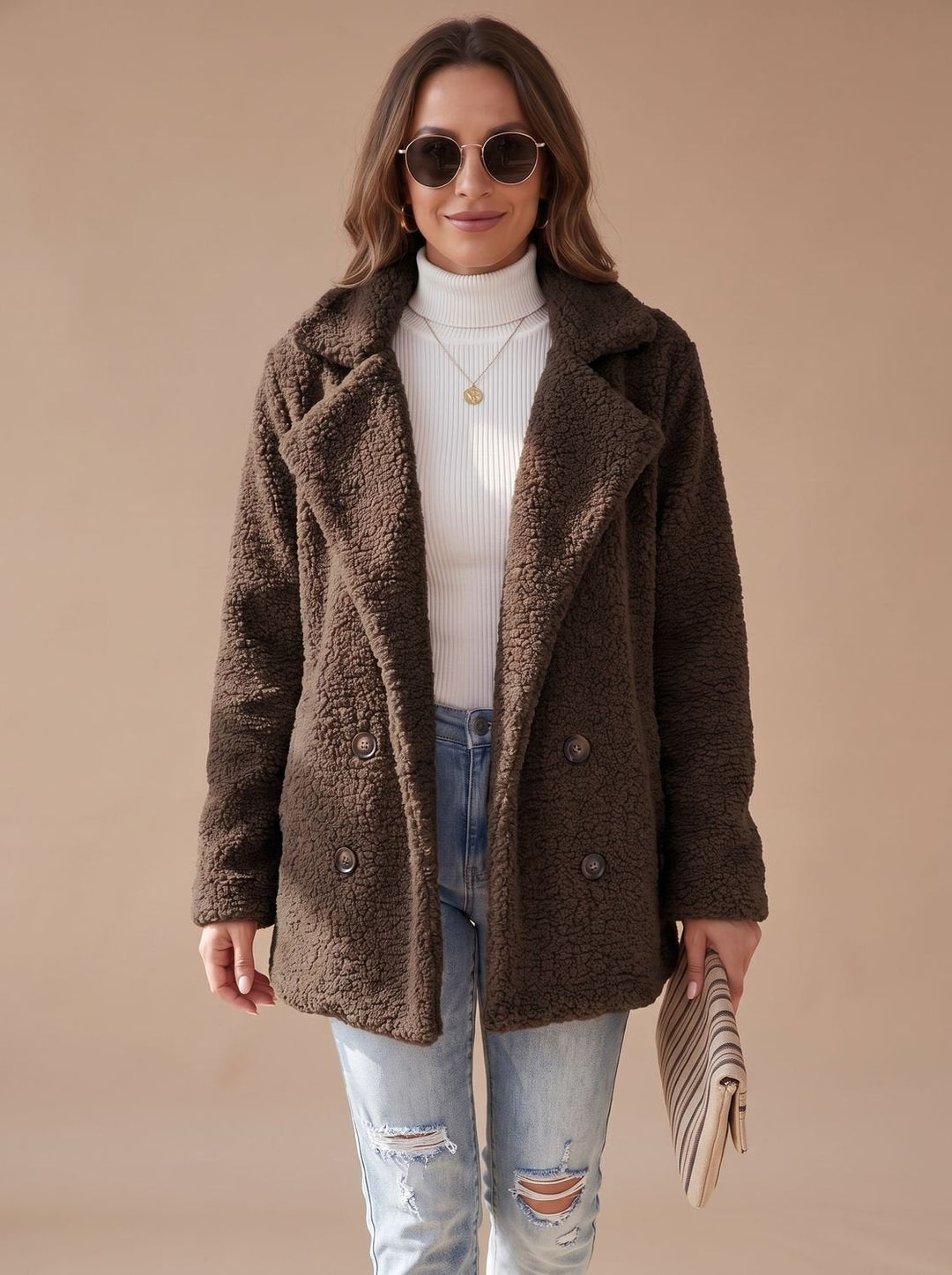 Dark brown teddy coat worn open with sunglasses and a striped clutch