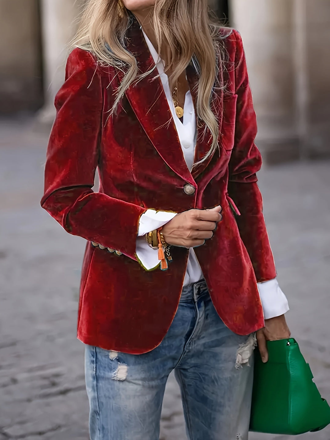 Dark red fitted blazer shown with a green bag and rolled white cuffs