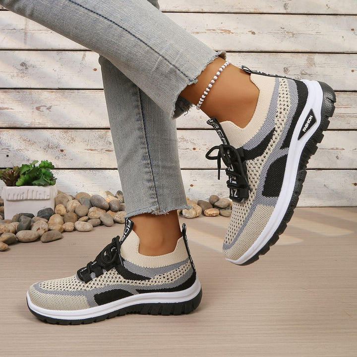 Beige Black walking trainers, worn on foot, side view