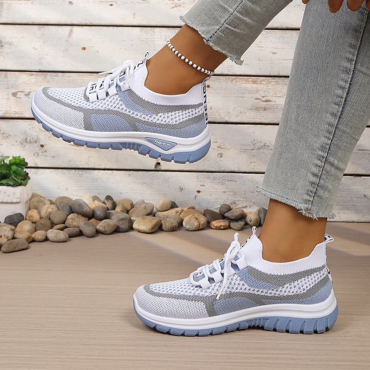 White Blue walking trainers, worn on foot, side view