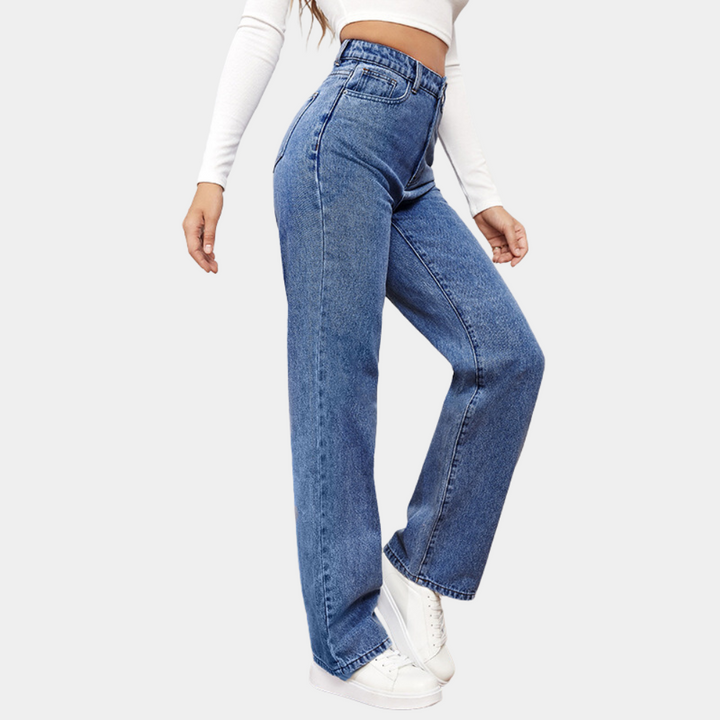 Mid blue high waisted jeans from the side, showing the wide leg