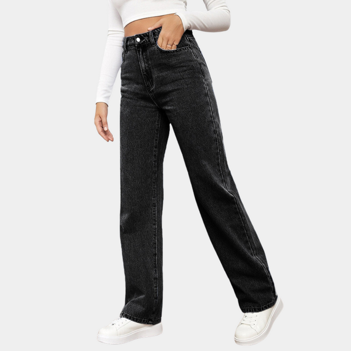 Washed black wide leg jeans worn with white trainers