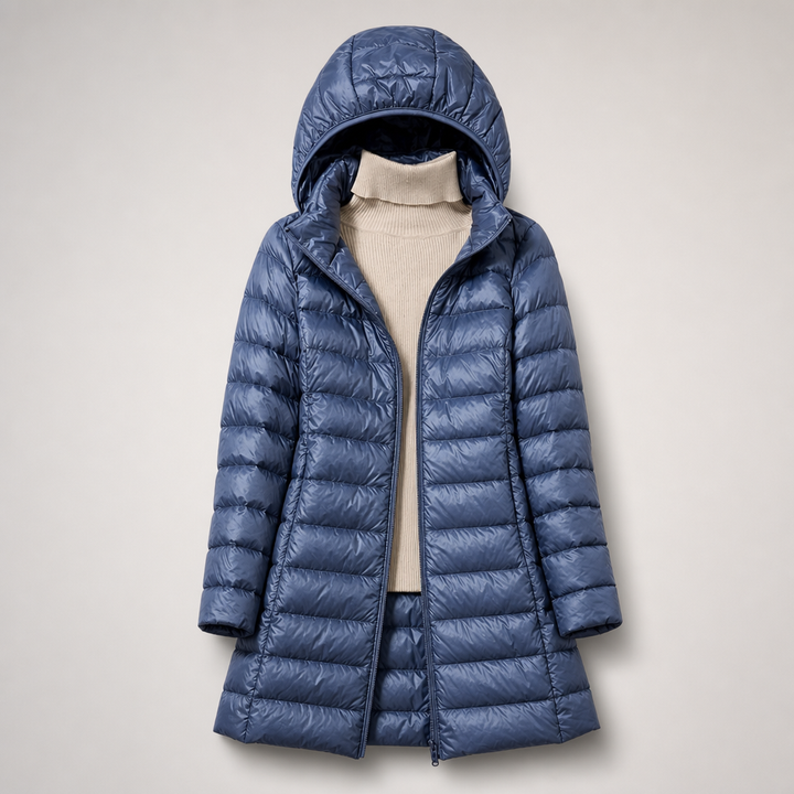 Blue long hooded padded coat worn open over a cream roll neck