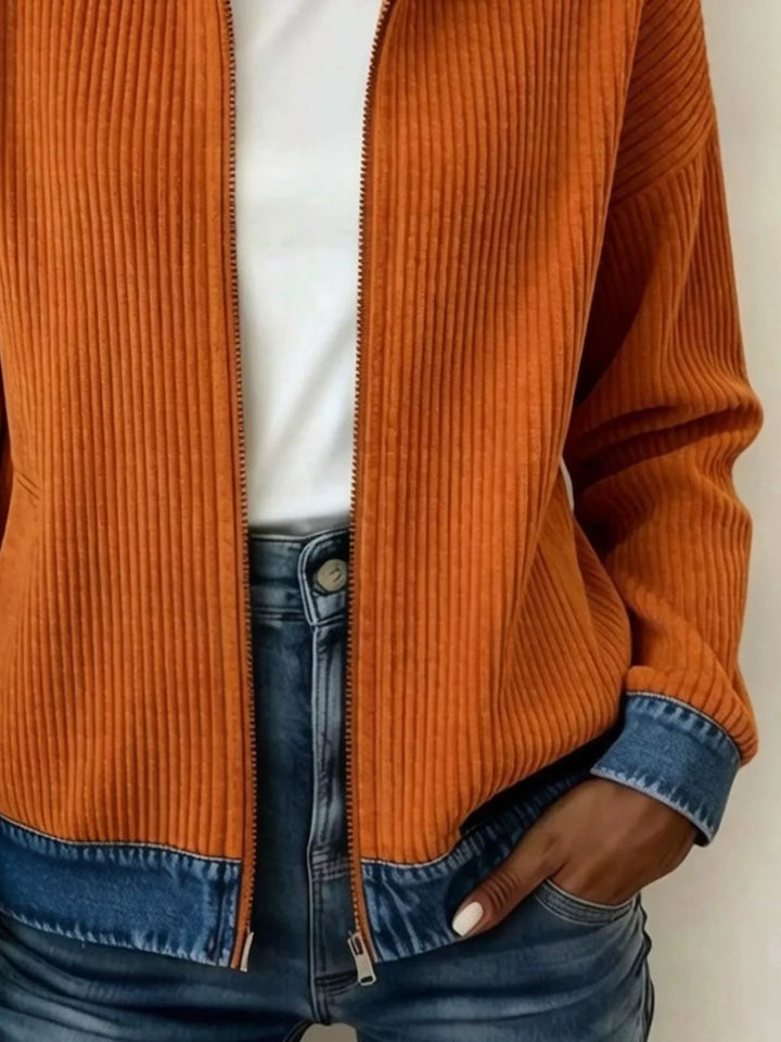 Close up of the burnt orange ribbed body, front zip and contrast hem